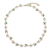 A silver gold plated necklace with green stones, pearls and shell flowers.